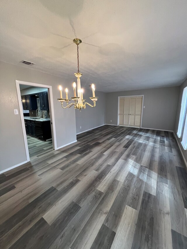 3222 Southland Blvd, San Angelo, TX 76904 - unfurnished dining area featuring a chandelier and dark wood-style flooring