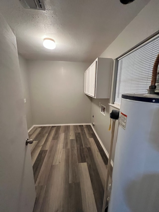 3222 Southland Blvd, San Angelo, TX 76904 - laundry room with cabinet space, water heater, dark wood-style floors, hookup for a washing machine, and a textured ceiling