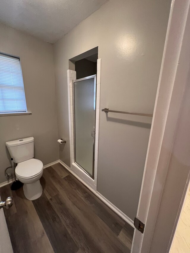 3222 Southland Blvd, San Angelo, TX 76904 - bathroom with wood finished floors, a stall shower, and a textured ceiling