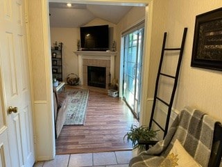 tiled living room with a fireplace and vaulted ceiling