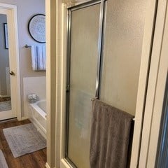 bathroom featuring hardwood / wood-style flooring and shower with separate bathtub