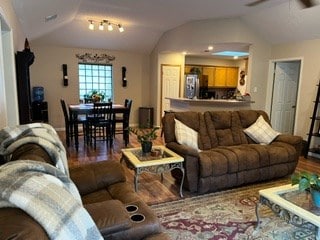 living room with wood-type flooring, lofted ceiling, and ceiling fan