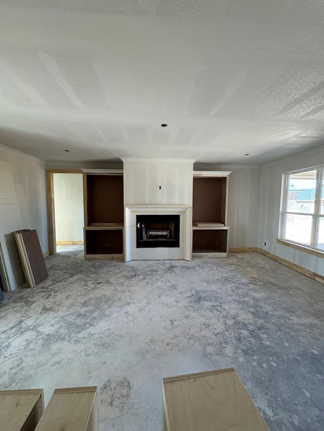 unfurnished living room with ornamental molding and a textured ceiling