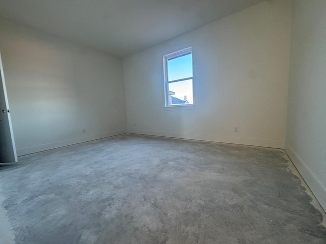 empty room featuring baseboards and unfinished concrete floors