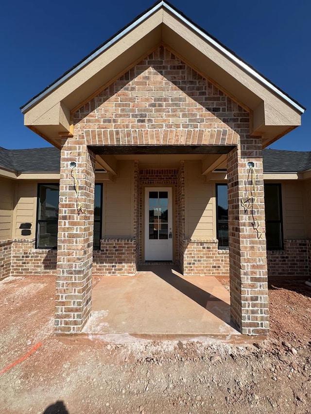 view of exterior entry with a patio