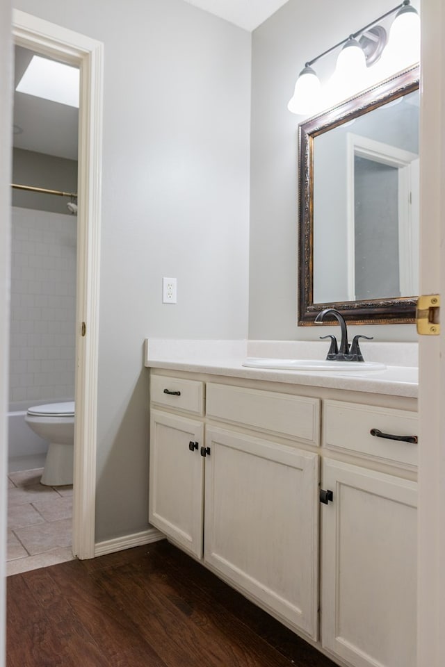 full bath with shower / washtub combination, vanity, toilet, and wood finished floors