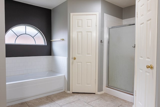 full bath featuring a garden tub, a shower stall, and tile patterned floors