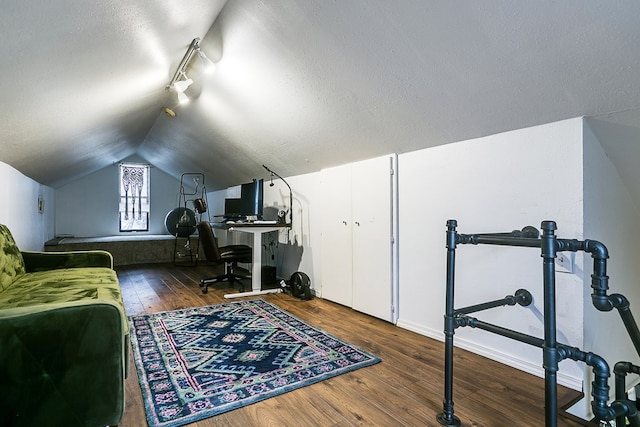 office space featuring dark wood-type flooring, track lighting, and lofted ceiling