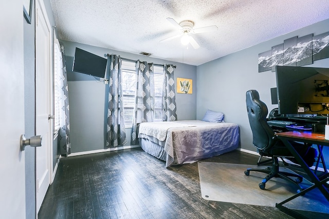 bedroom with dark wood-type flooring, a textured ceiling, and ceiling fan