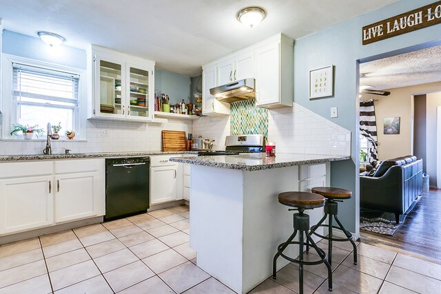 kitchen with electric stove, white cabinetry, black dishwasher, stone countertops, and decorative backsplash