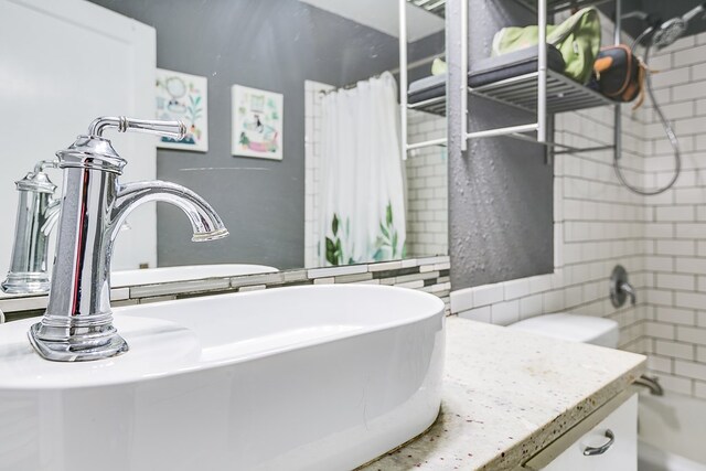 bathroom featuring shower / bathtub combination with curtain and sink