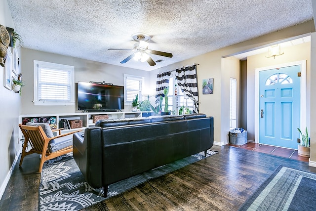 living room featuring ceiling fan, a textured ceiling, and dark hardwood / wood-style flooring