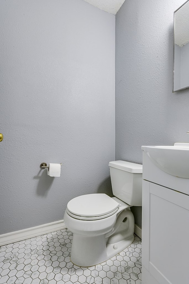 bathroom with tile patterned flooring, vanity, and toilet