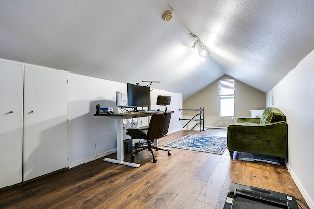 office space featuring dark wood-type flooring, vaulted ceiling, and a textured ceiling