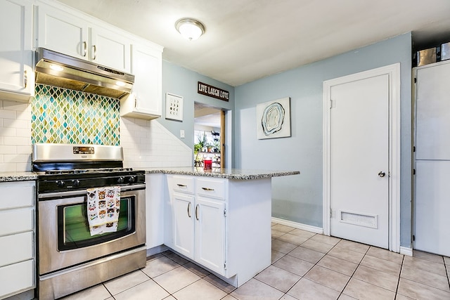 kitchen featuring stainless steel gas range oven, white cabinetry, light tile patterned floors, kitchen peninsula, and decorative backsplash