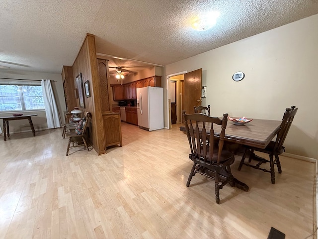 dining area with ceiling fan, a textured ceiling, and light hardwood / wood-style floors