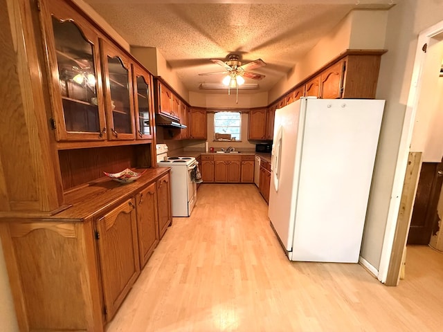 kitchen featuring sink, white appliances, light hardwood / wood-style flooring, a textured ceiling, and ceiling fan