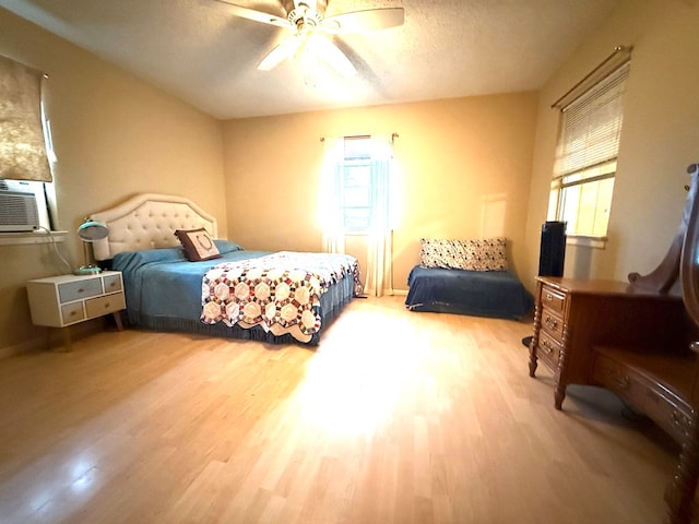 bedroom with multiple windows, wood-type flooring, and a textured ceiling