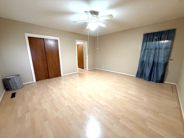 unfurnished bedroom with ceiling fan, light hardwood / wood-style floors, and a closet