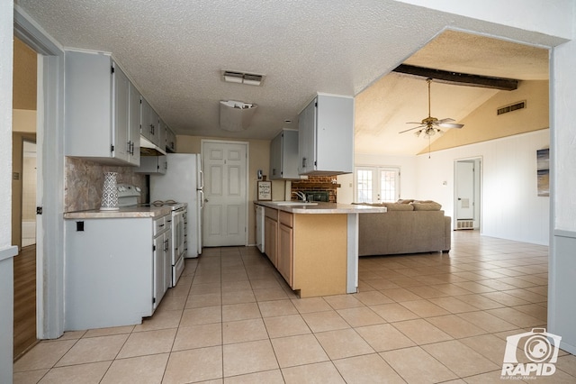 kitchen featuring vaulted ceiling with beams, sink, decorative backsplash, light tile patterned floors, and kitchen peninsula