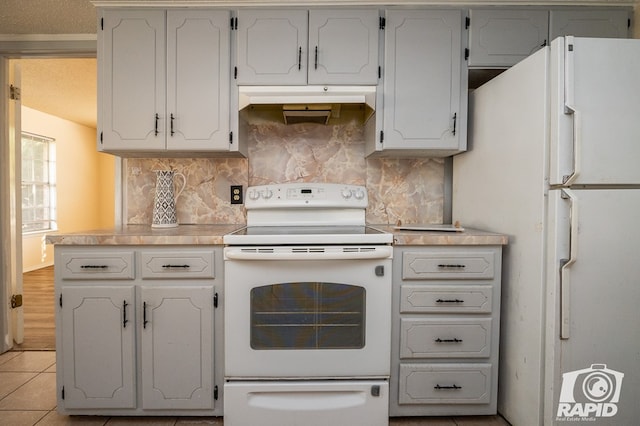 kitchen featuring light tile patterned floors, white cabinets, white appliances, and decorative backsplash