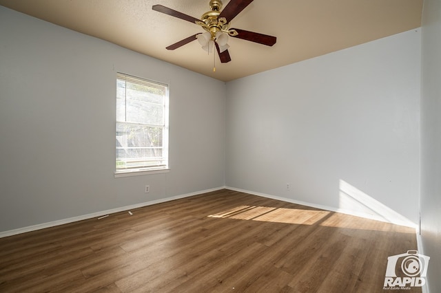 spare room featuring dark hardwood / wood-style floors and ceiling fan