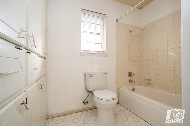 bathroom with tiled shower / bath combo and toilet