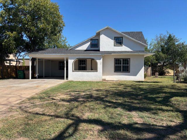 view of front of house featuring a carport and a front yard