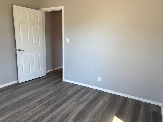 unfurnished room with dark hardwood / wood-style floors