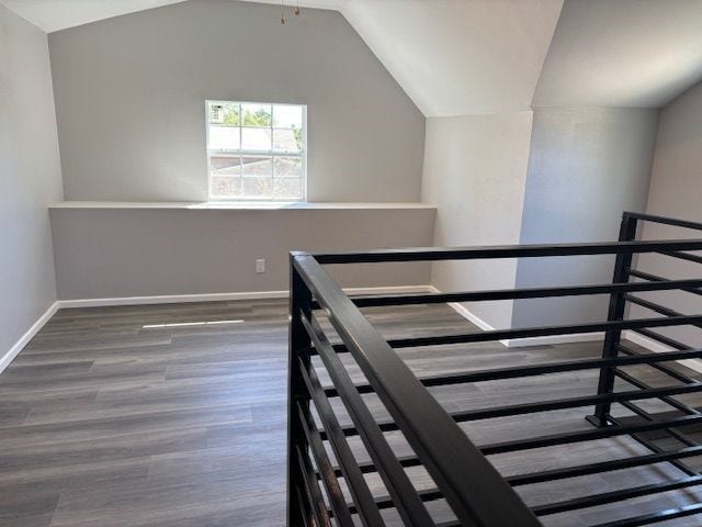 stairway featuring hardwood / wood-style floors and vaulted ceiling