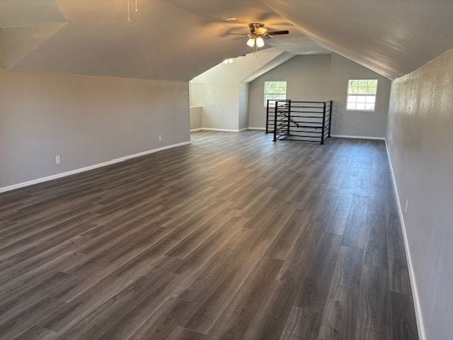 additional living space with vaulted ceiling, dark wood-type flooring, and ceiling fan