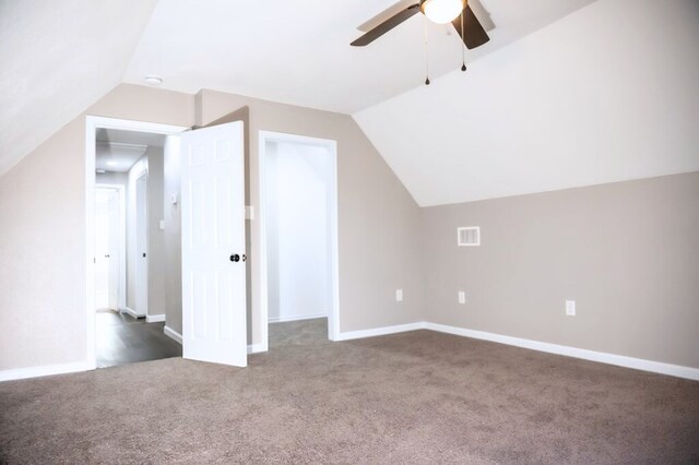 additional living space with vaulted ceiling, ceiling fan, and dark carpet