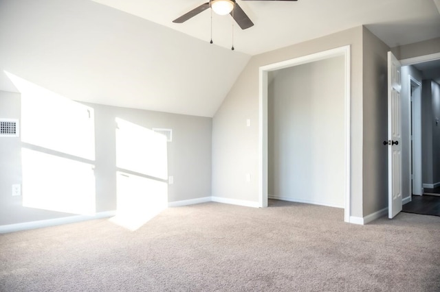 interior space with vaulted ceiling, light carpet, and ceiling fan