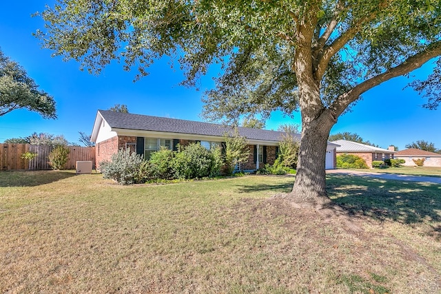 ranch-style home with a garage and a front lawn