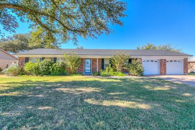 ranch-style home with a garage and a front yard