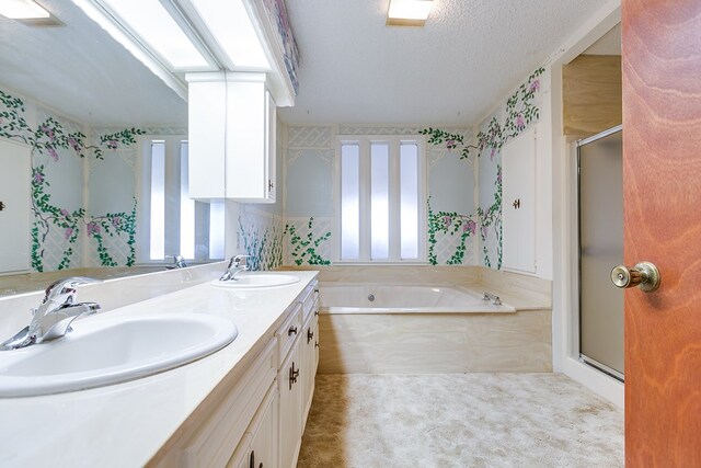 bathroom featuring a skylight, vanity, a textured ceiling, and plus walk in shower