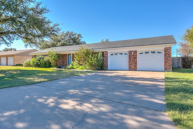 ranch-style home with a garage and a front lawn