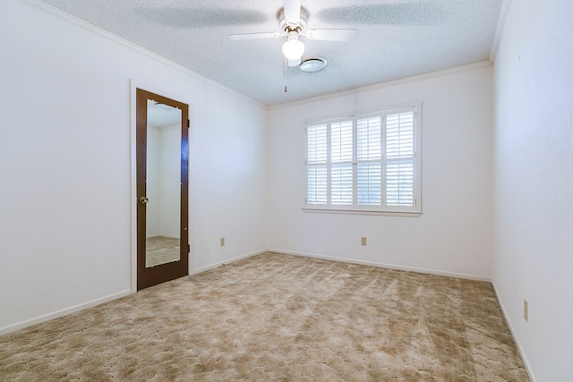 carpeted spare room with ornamental molding, ceiling fan, and a textured ceiling