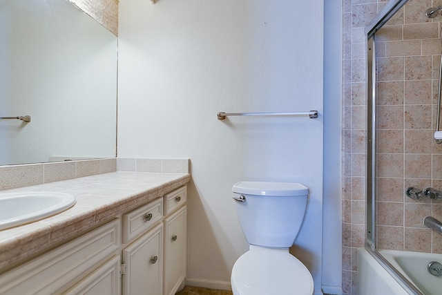 full bathroom with enclosed tub / shower combo, vanity, and toilet