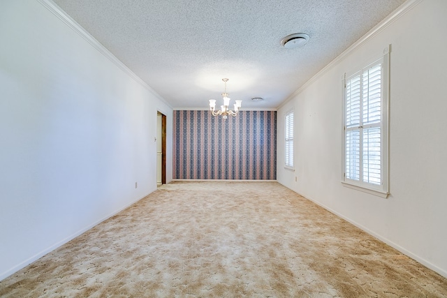 carpeted empty room featuring an inviting chandelier, crown molding, and a textured ceiling