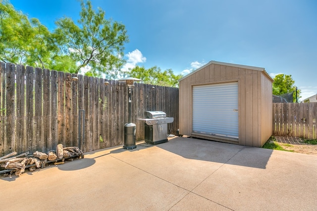 view of patio / terrace with a storage shed, a fenced backyard, a grill, and an outdoor structure