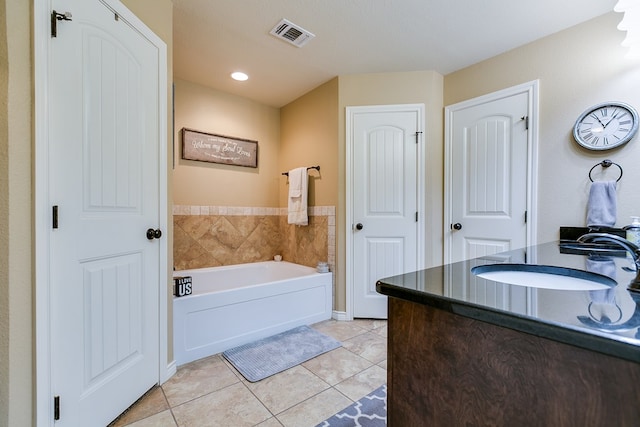 full bathroom with tile patterned floors, a garden tub, visible vents, and a sink