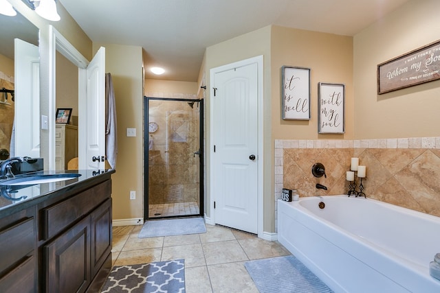full bath featuring a shower stall, a garden tub, tile patterned floors, vanity, and baseboards