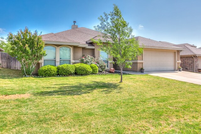 view of front of home with stucco siding, an attached garage, a front yard, and concrete driveway