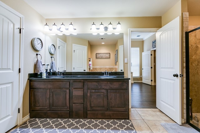 bathroom with double vanity, tile patterned floors, a stall shower, and a sink