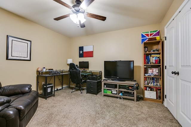 carpeted home office with a ceiling fan