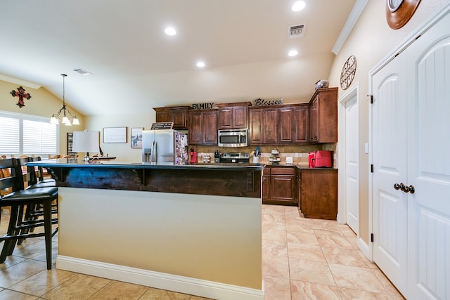 kitchen featuring dark countertops, vaulted ceiling, appliances with stainless steel finishes, and crown molding