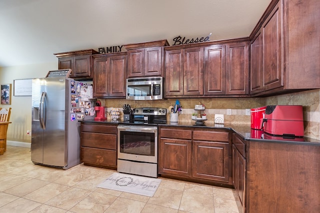 kitchen with dark countertops, decorative backsplash, and appliances with stainless steel finishes