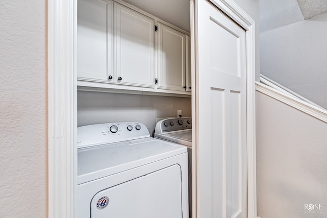 laundry area with cabinets and washer and clothes dryer