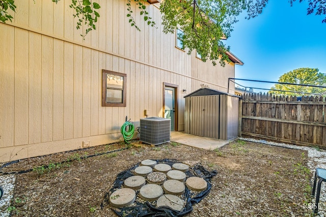 view of yard with central AC, a patio, and a storage unit